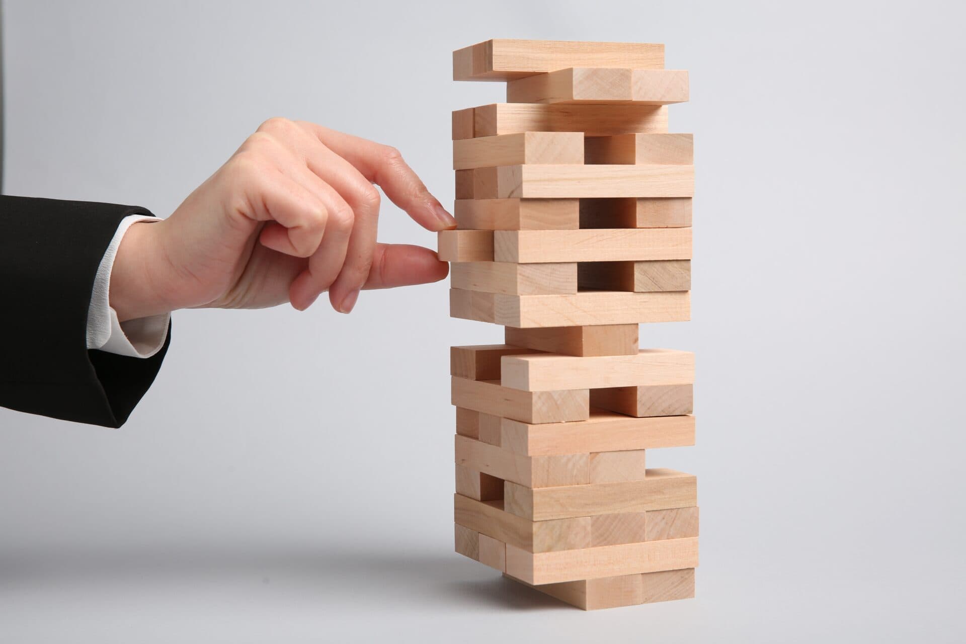 Woman,playing,jenga,on,light,gray,background,,closeup